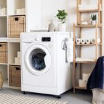 Laundry room with a front-loading washing machine and organized supplies