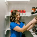 Person reaching for food on organized pantry shelves