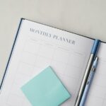 Paper notebook and digital planning device used together on a desk
