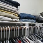 Folded clothing organized on closet shelves with clear dividers