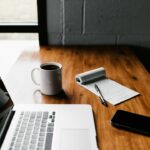 Laptop and notebook on a desk for grouping and planning similar work